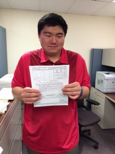 Tyrus Suezaki proudly presents one of his paychecks he earned during his summer as an Summer Youth Employment Program intern. 